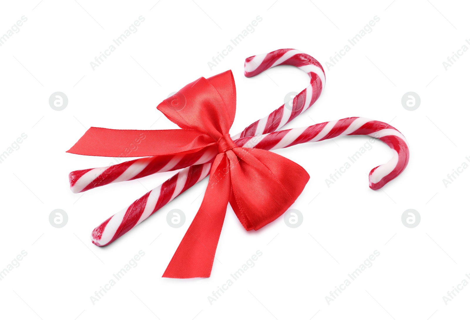 Photo of Sweet Christmas candy canes with red bow on white background