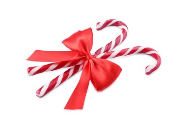 Sweet Christmas candy canes with red bow on white background