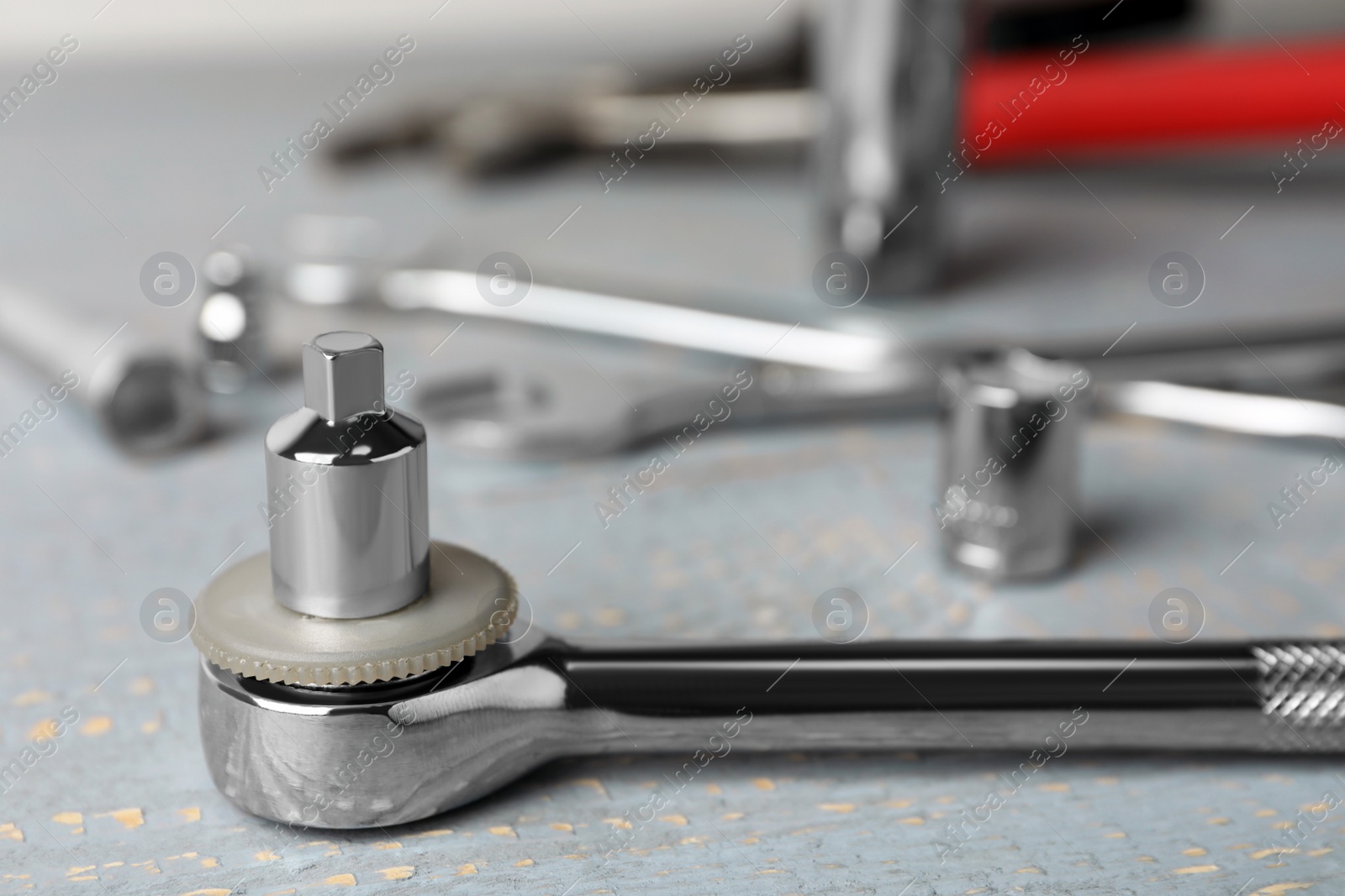 Photo of Auto mechanic's tool on grey wooden table, closeup