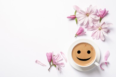 Image of Beautiful pink magnolia flowers and cup of aromatic coffee on white background, top view. Good morning