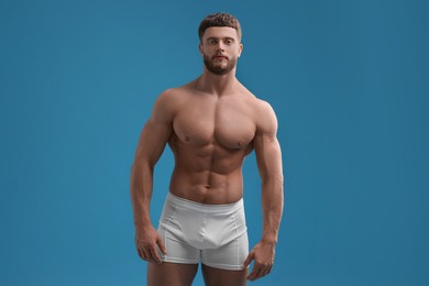 Photo of Handsome muscular man on light blue background. Sexy body