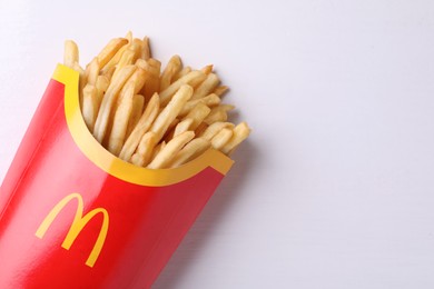 MYKOLAIV, UKRAINE - AUGUST 12, 2021: Big portion of McDonald's French fries on white wooden table, top view. Space for text