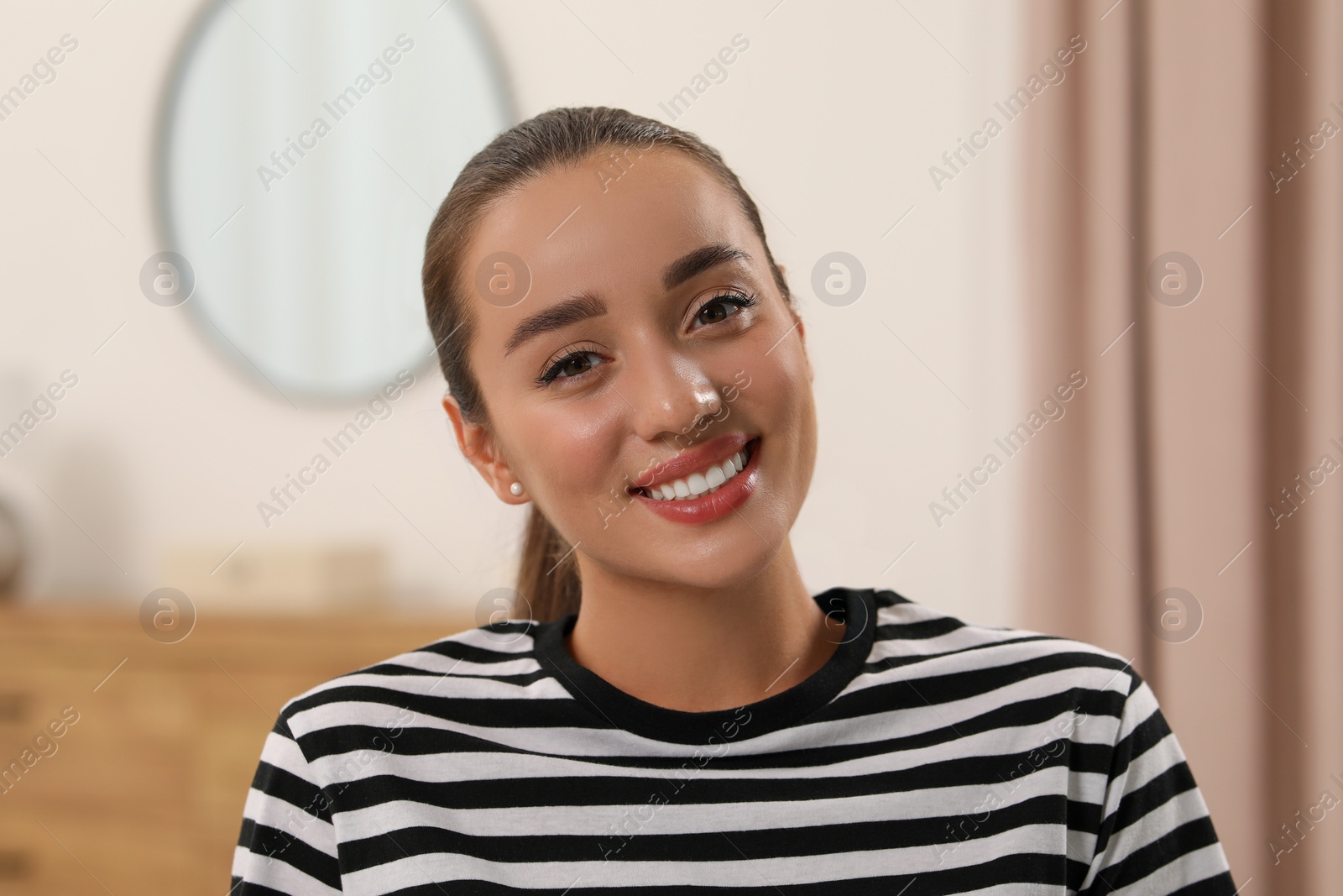 Photo of Portrait of beautiful young woman indoors. Attractive lady smiling and looking into camera