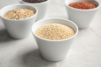 Bowl with white quinoa seeds on table