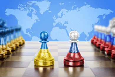 Image of Concept of war between Ukraine and Russia. Chess pieces in color of national flags on wooden board against world map