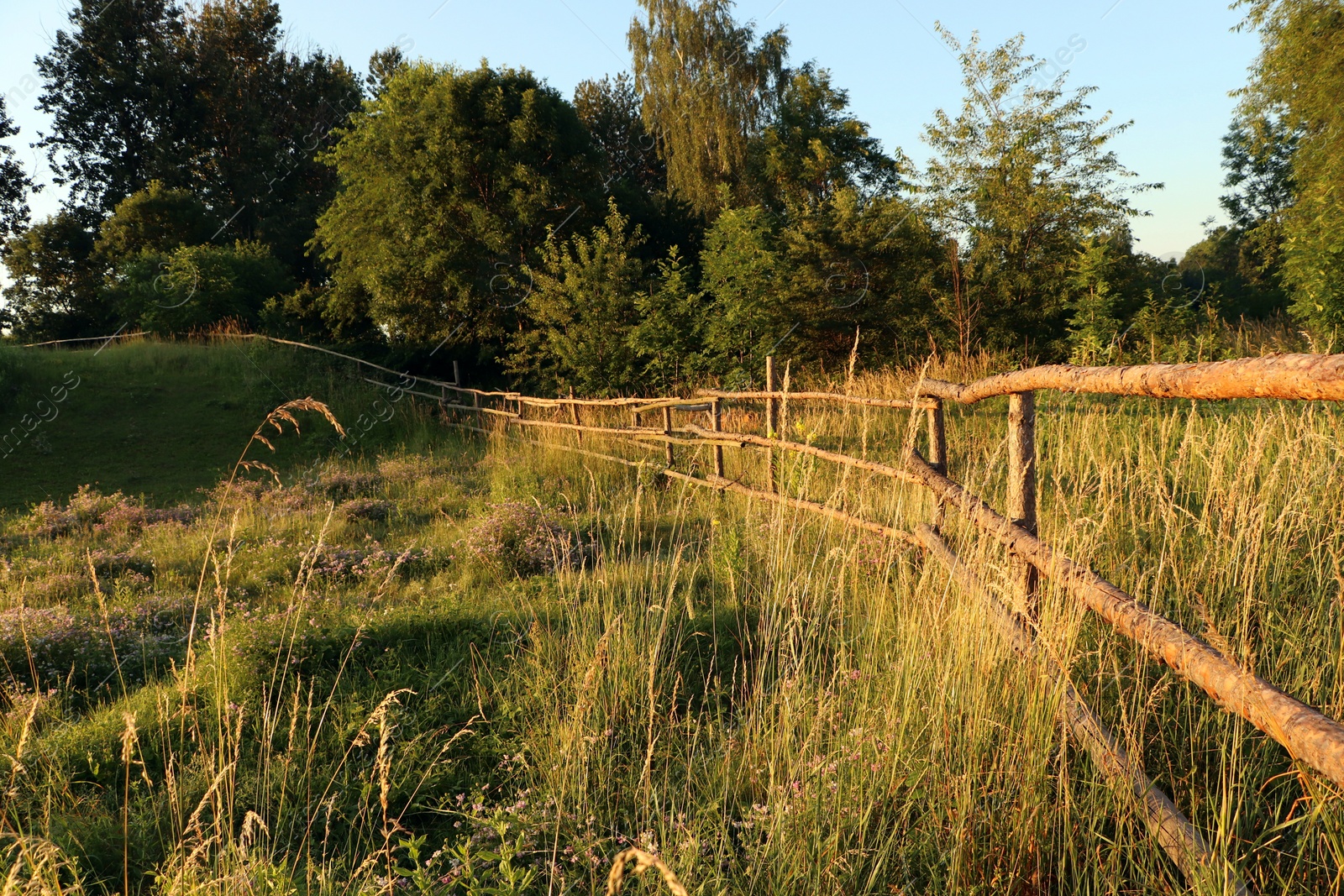 Photo of Picturesque view of countryside with wooden fence in morning