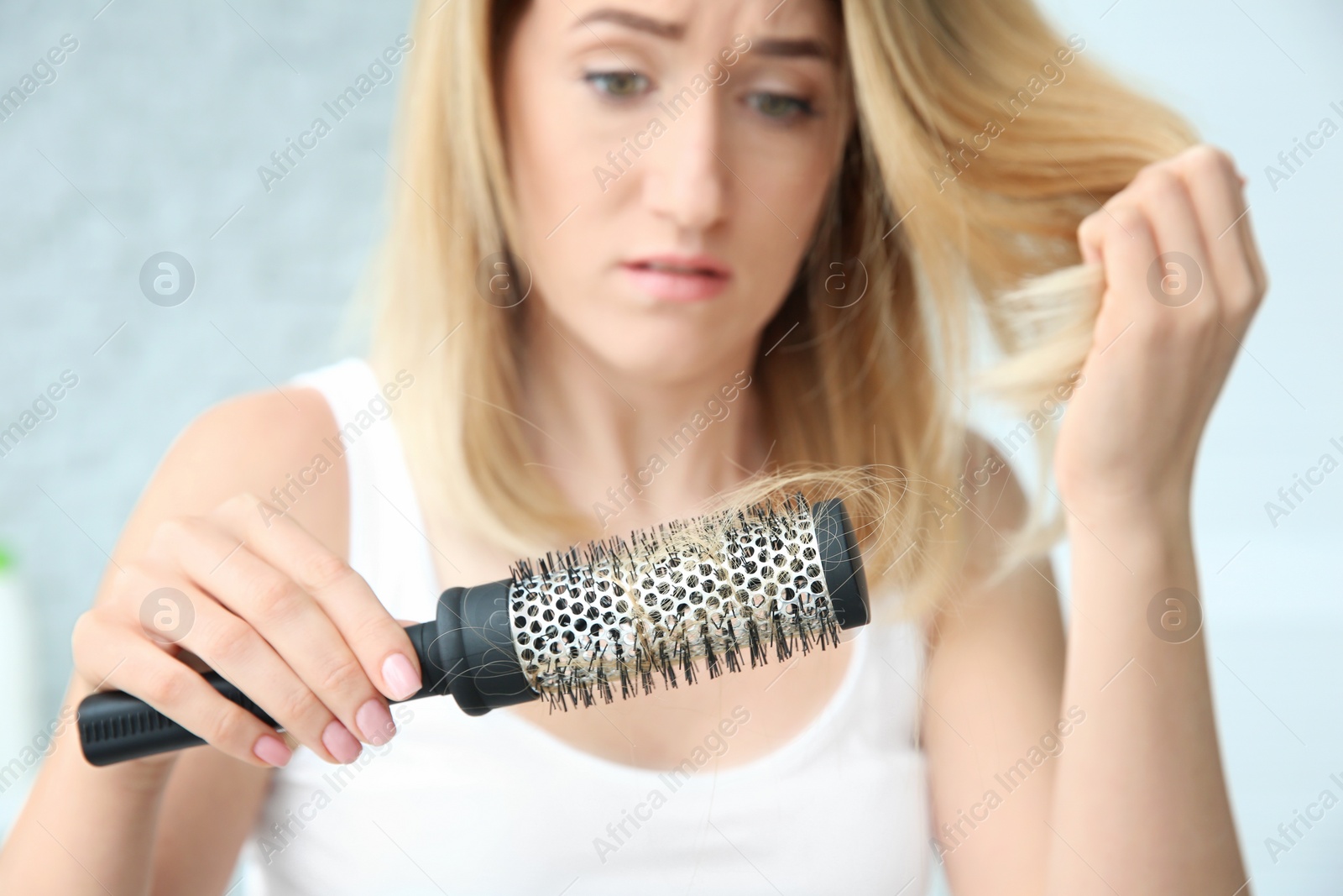 Photo of Young woman with hair loss problem at home