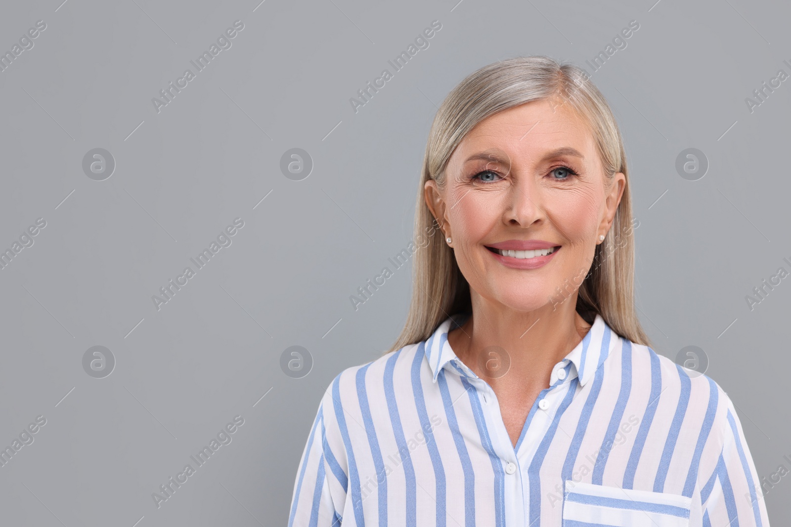 Photo of Portrait of beautiful middle aged woman on light grey background, space for text