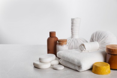 Photo of Spa composition with care products on light grey marble table. Space for text
