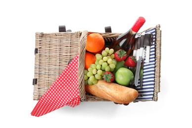 Wicker picnic basket with wine and different products on white background, top view