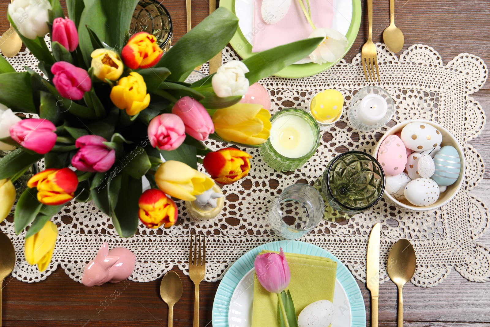 Photo of Festive table setting with beautiful flowers, flat lay. Easter celebration