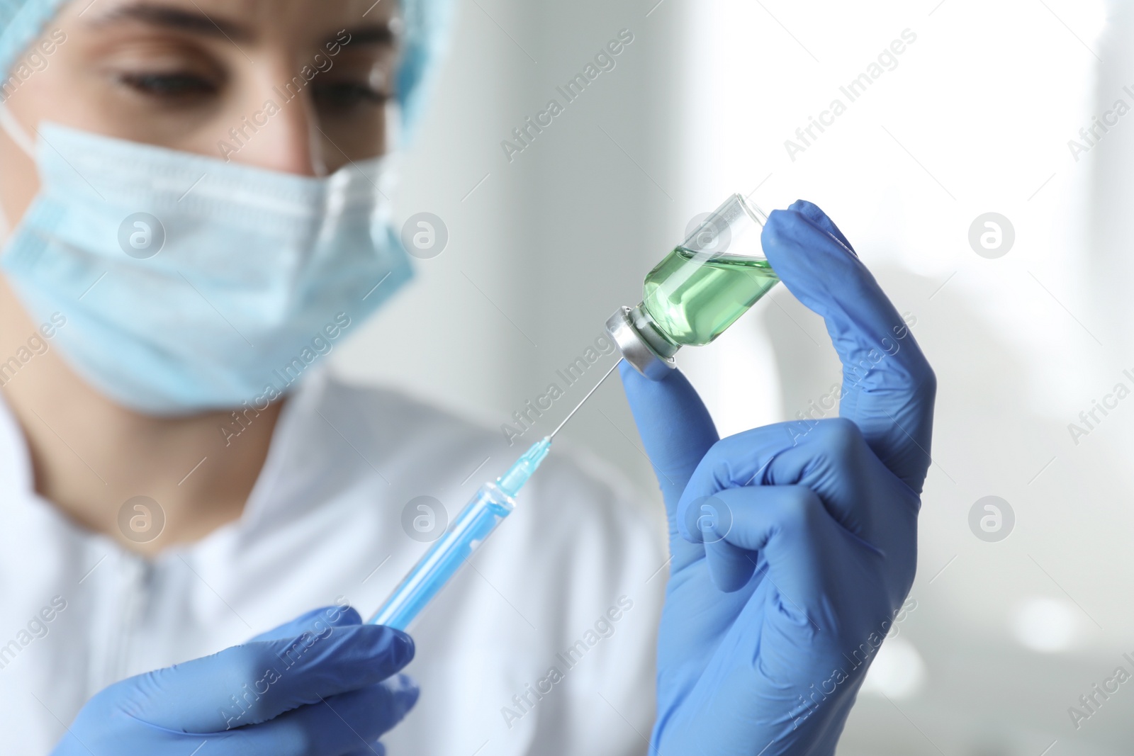 Photo of Doctor filling syringe with medication in clinic, focus on hands. Vaccination and immunization