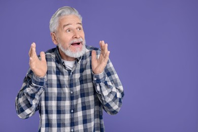 Photo of Portrait of surprised senior man on violet background, space for text