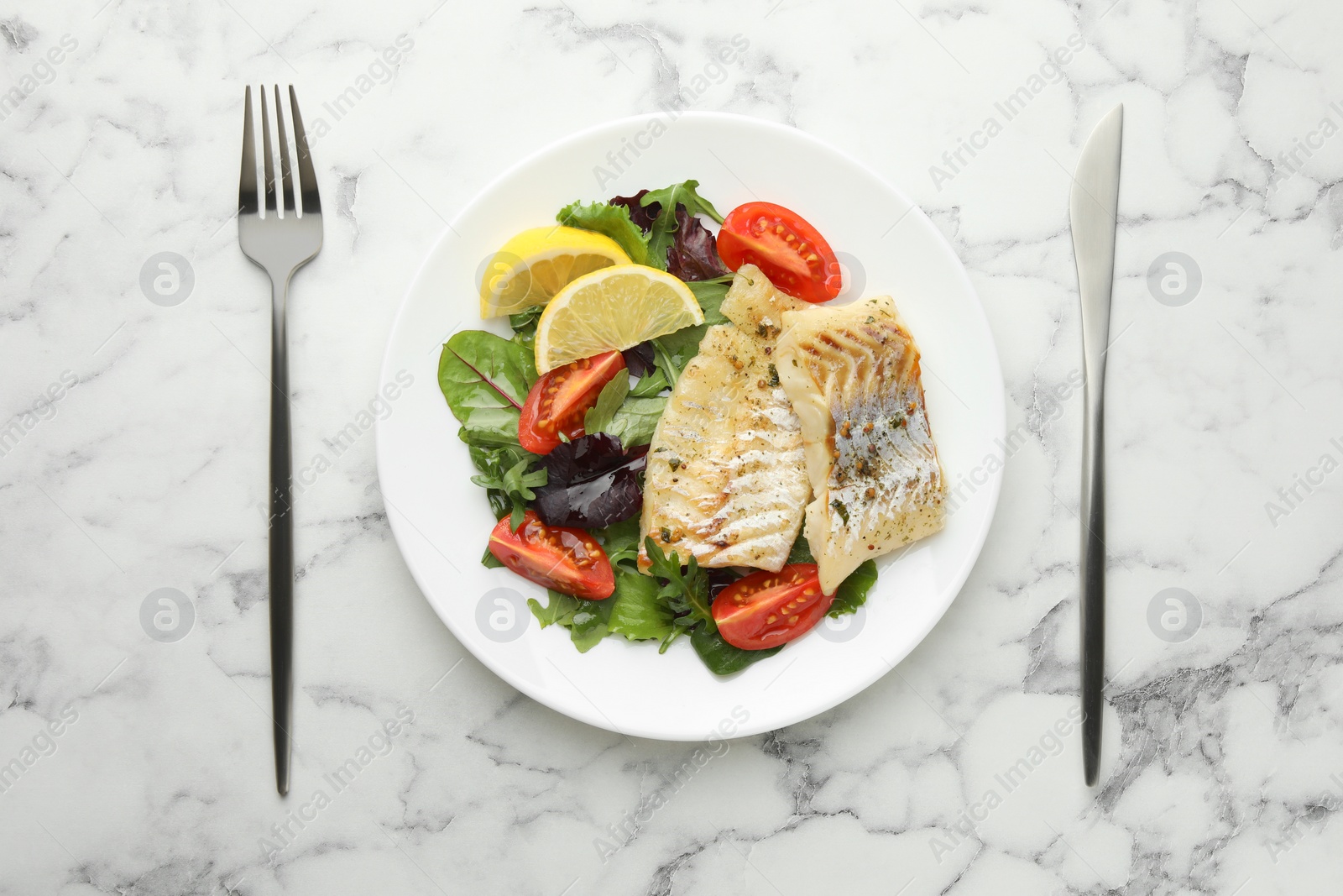 Photo of Tasty cod cooked served with salad on white marble table, flat lay