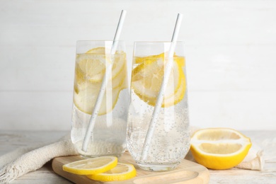 Photo of Soda water with lemon slices and fresh fruits on table