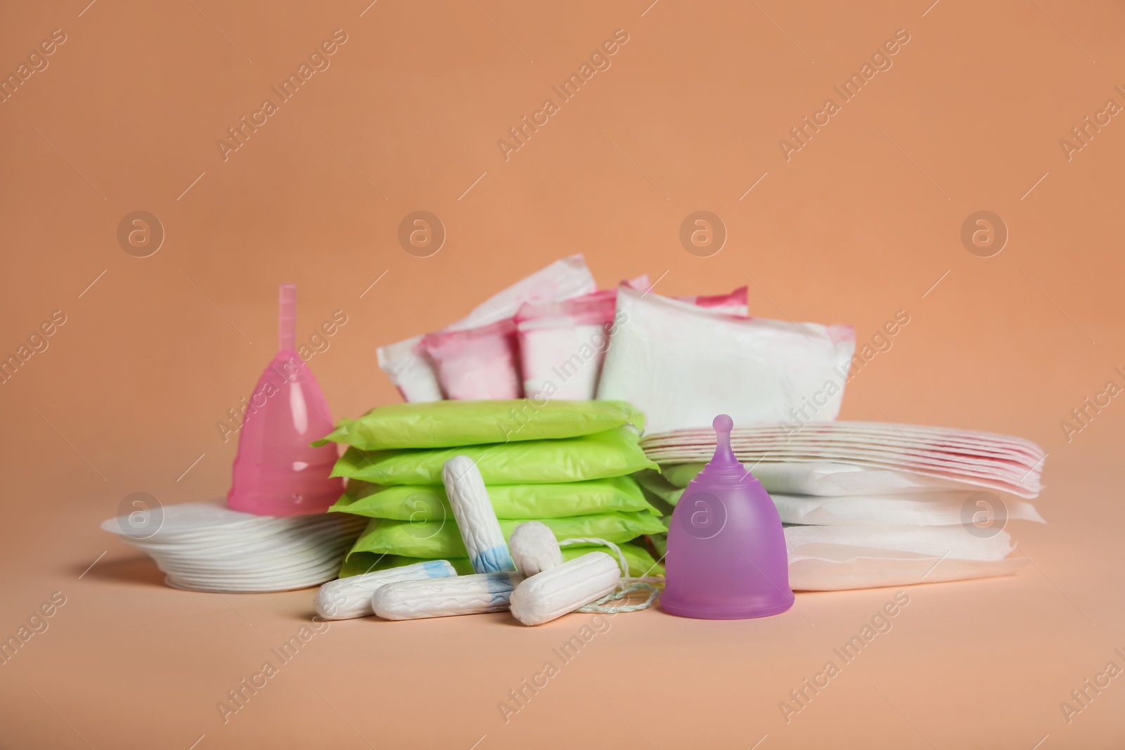 Photo of Menstrual pads and other period products on pale orange background