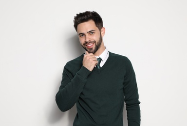 Portrait of handsome young man smiling on light background