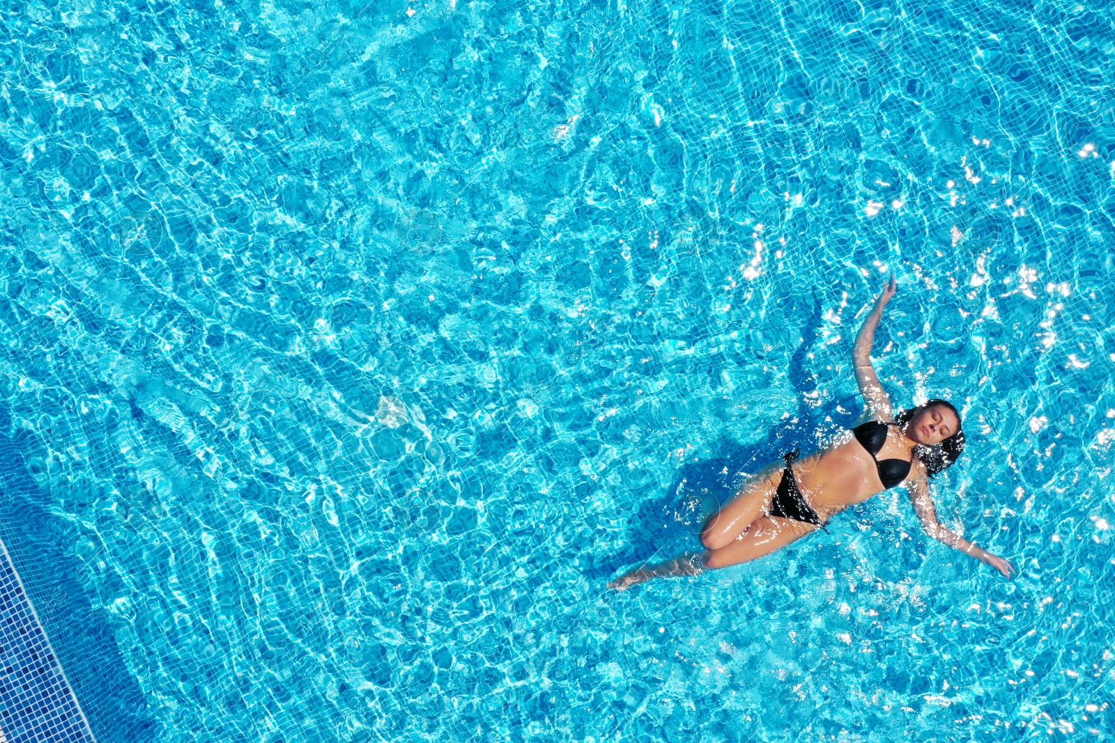 Image of Beautiful young woman swimming in pool, top view. Space for text