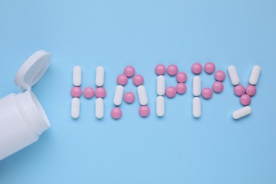 Photo of Word Happy made of antidepressants and medical jar on light blue background, flat lay