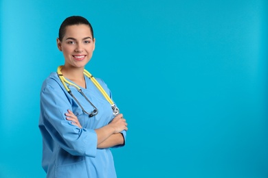 Portrait of young medical assistant with stethoscope on color background. Space for text