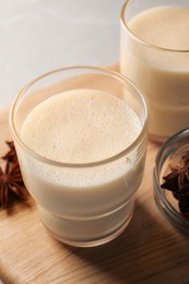 Photo of Glasses of delicious eggnog with anise on grey marble table, closeup