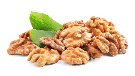 Pile of peeled walnuts and leaves on white background