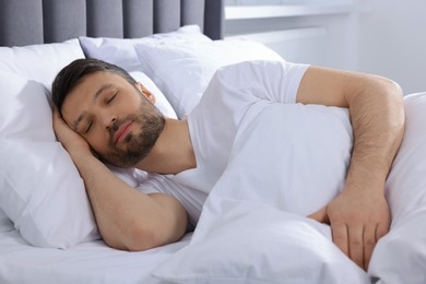 Photo of Handsome man sleeping in soft bed at home