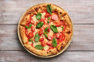 Photo of Delicious Margherita pizza on wooden table, top view