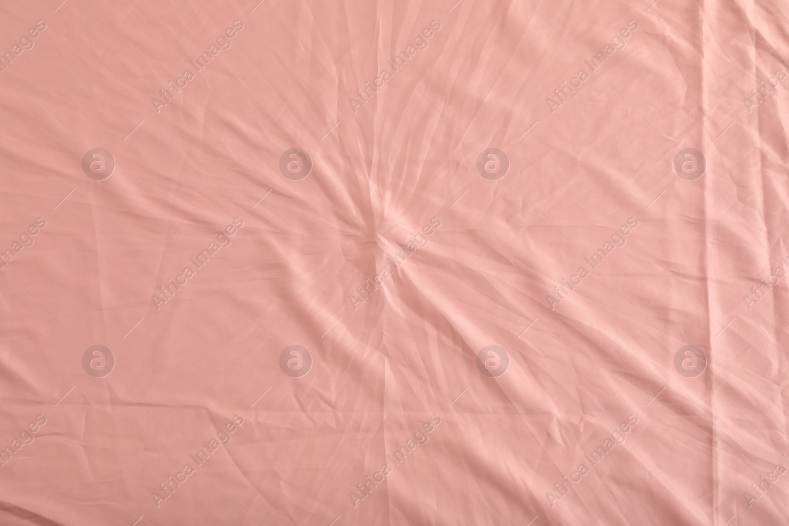 Photo of Crumpled coral fabric as background, top view