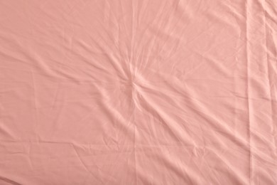 Crumpled coral fabric as background, top view