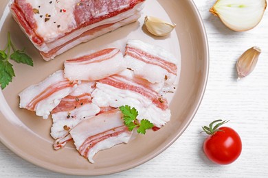 Photo of Tasty salt pork with parsley served on white wooden table, flat lay