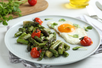 Photo of Oven baked asparagus served with fried egg on plate