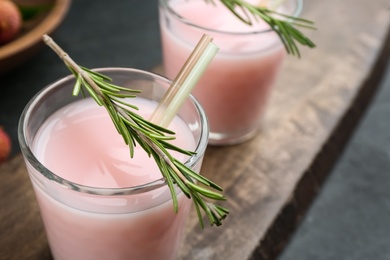 Photo of Delicious lychee cocktail with rosemary on table, closeup. Space for text