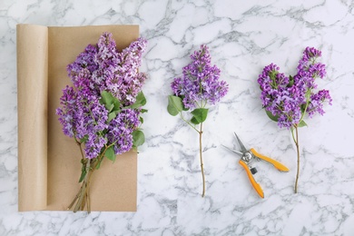 Flat lay composition with beautiful blossoming lilac on light background. Spring flowers