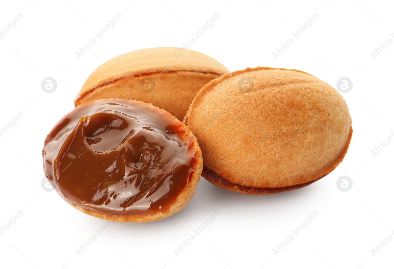 Photo of Delicious nut shaped cookies with boiled condensed milk on white background