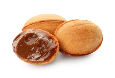 Photo of Delicious nut shaped cookies with boiled condensed milk on white background