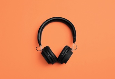 Stylish headphones on color background, top view