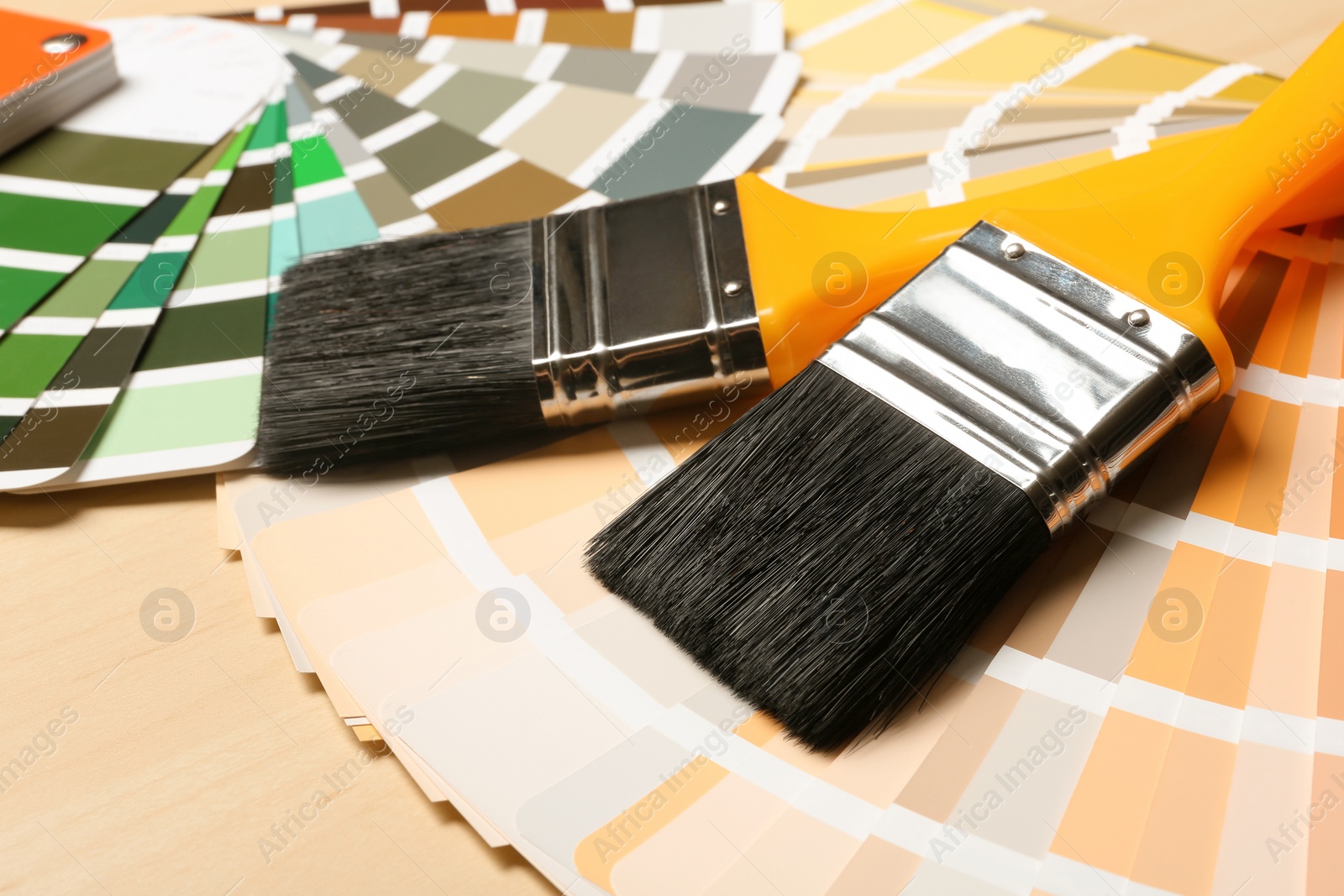 Photo of Paint brushes and color palettes on table, closeup