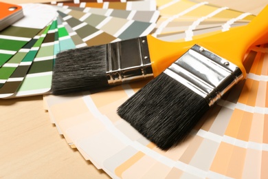 Photo of Paint brushes and color palettes on table, closeup