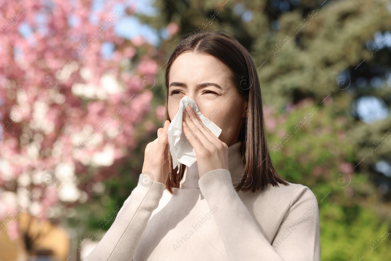 Photo of Woman with napkin suffering from seasonal allergy on spring day