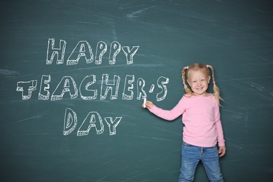 Image of Cute little girl pointing on chalkboard with text Happy Teacher's Day