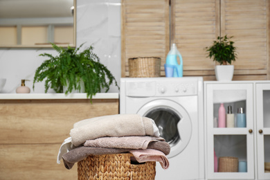 Wicker basket with laundry in bathroom. Space for text