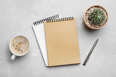 Photo of Flat lay composition with notebooks and cup of coffee on grey background