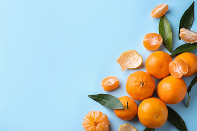 Photo of Fresh ripe tangerines on light blue background, flat lay. Space for text