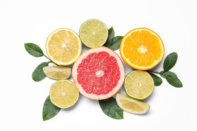 Photo of Different cut citrus fruits and leaves on white table, flat lay