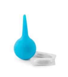 Photo of Light blue enema and suppositories on white background
