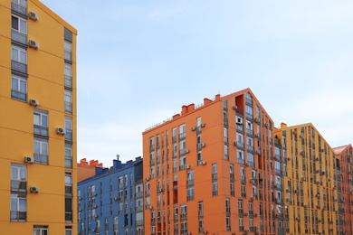 Photo of Colorful modern buildings with windows against sky. Urban architecture