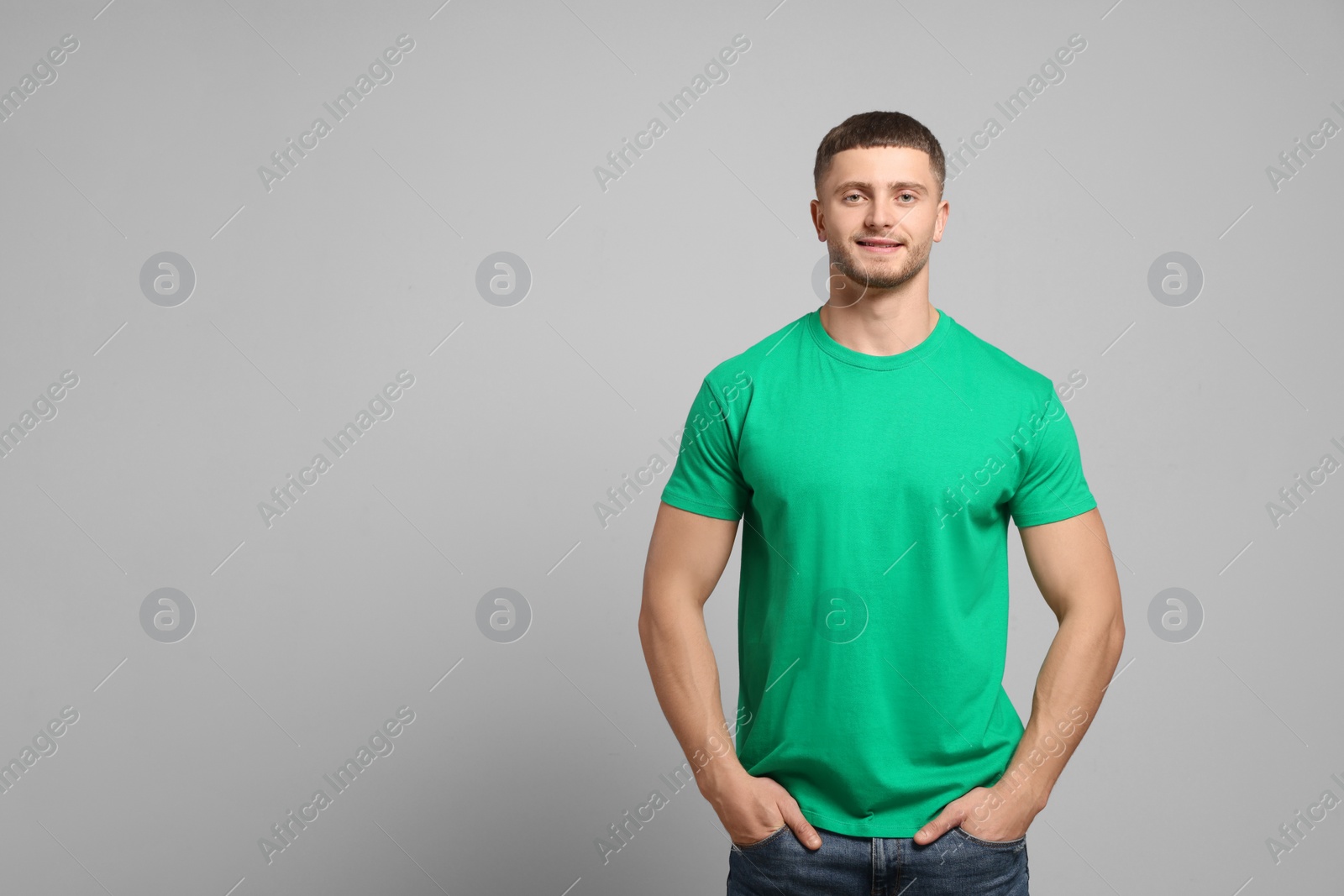 Photo of Man wearing green t-shirt on light grey background. Mockup for design