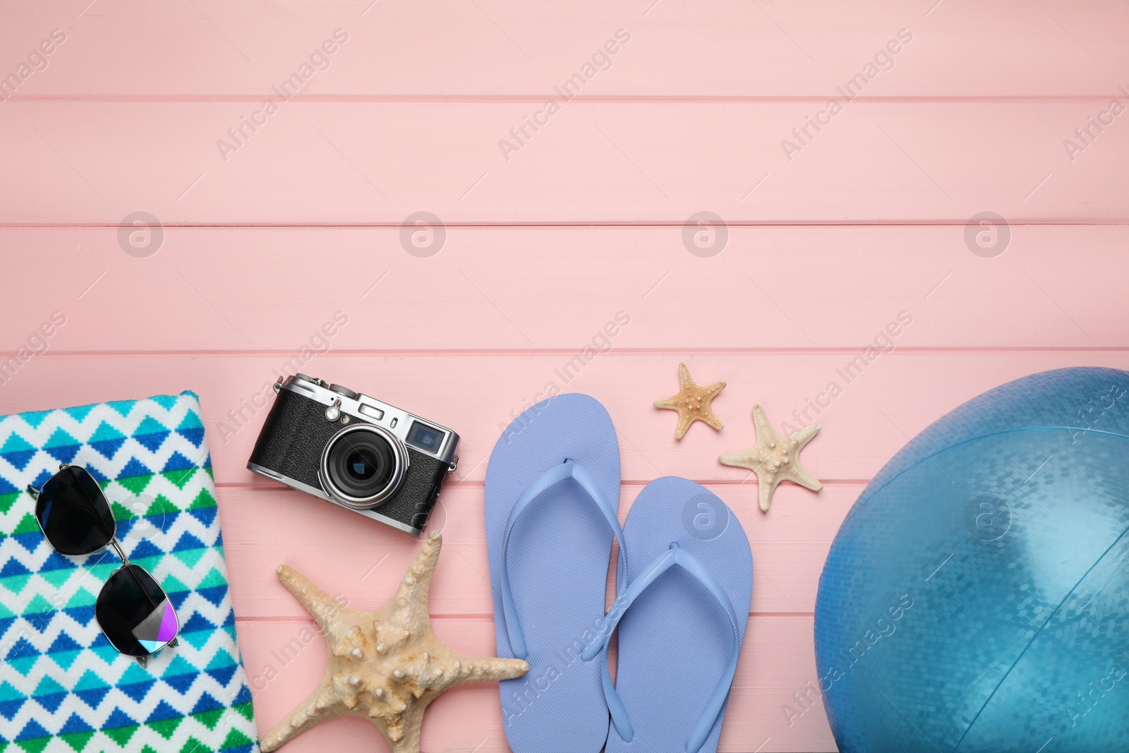 Photo of Flat lay composition with beach ball on pink wooden background. Space for text