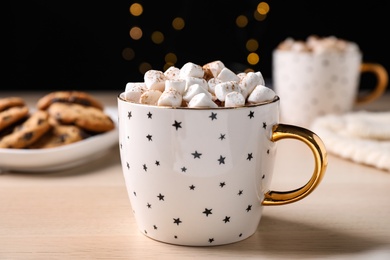 Photo of Cup of hot drink with marshmallows on wooden table